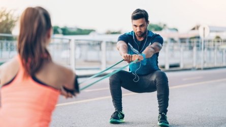 An image showing a man training with a resistance band as part of his resistance training.