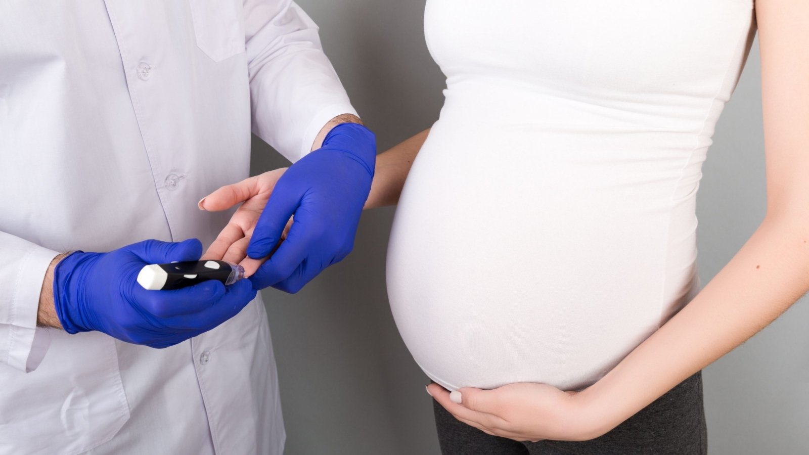 An Obstetrician measuring blood sugar of a pregnant woman for gestational diabetes.