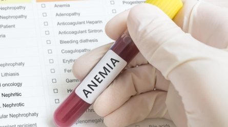 A researcher holds a test tube with blood for anemia test.